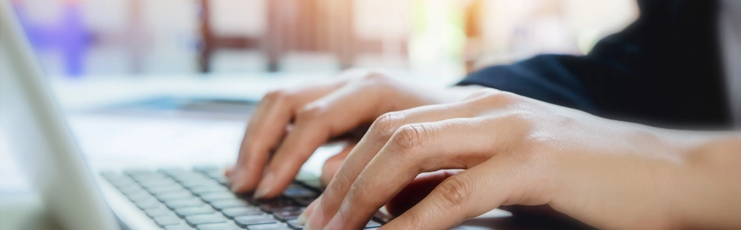 woman hands typing on laptop keyboard